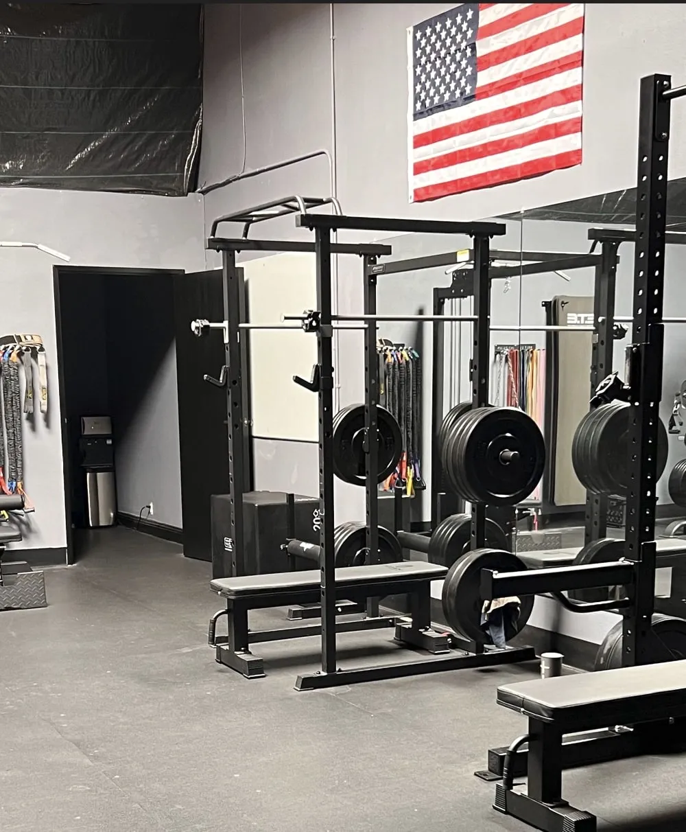 The rack and weight wall on the Iron Ambition training floor