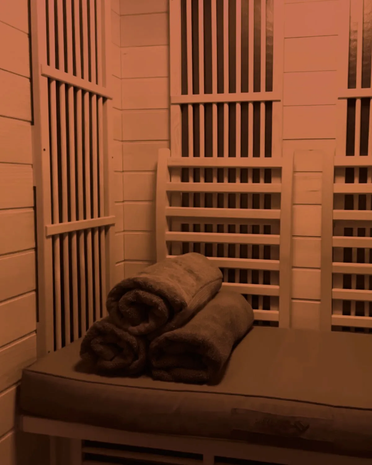 Inside the infrared sauna — cedar benches, towels, red light