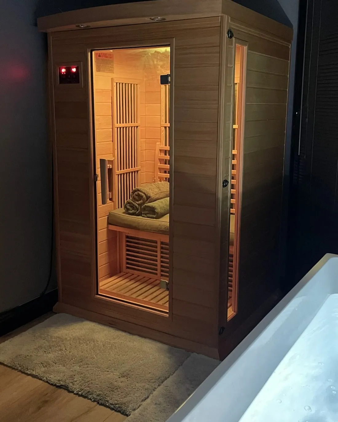 The infrared sauna at Iron Ambition, cedar and lit from within, beside the cold plunge